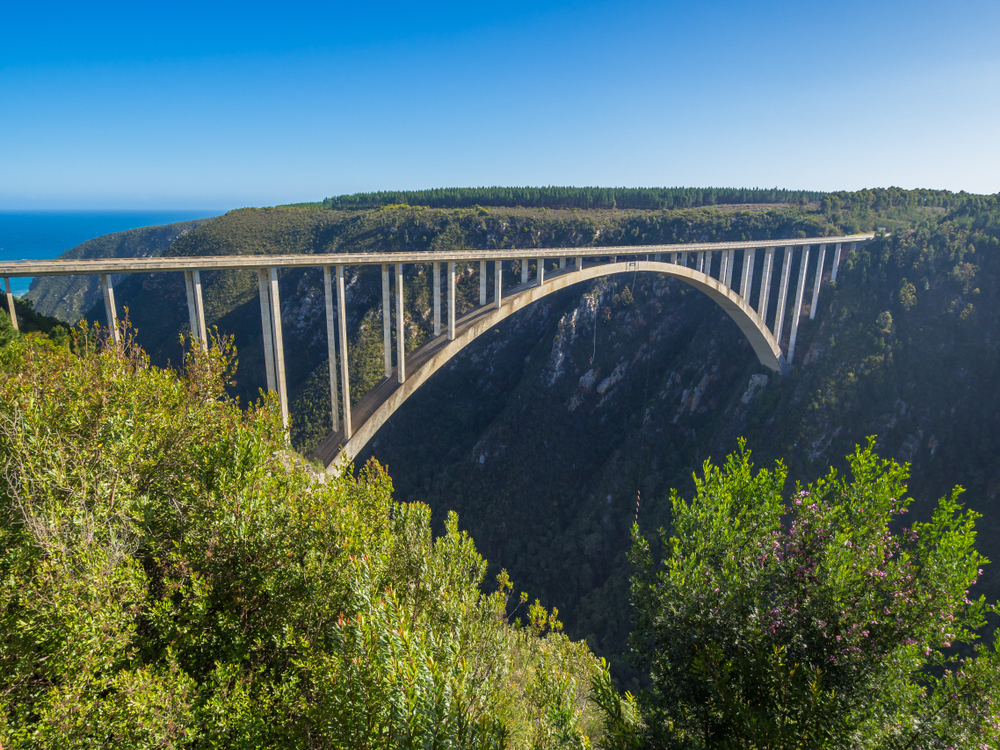 Garden Route - Famous Bloukrans Bridge with ocean in background and bungee jumpers, South Africa